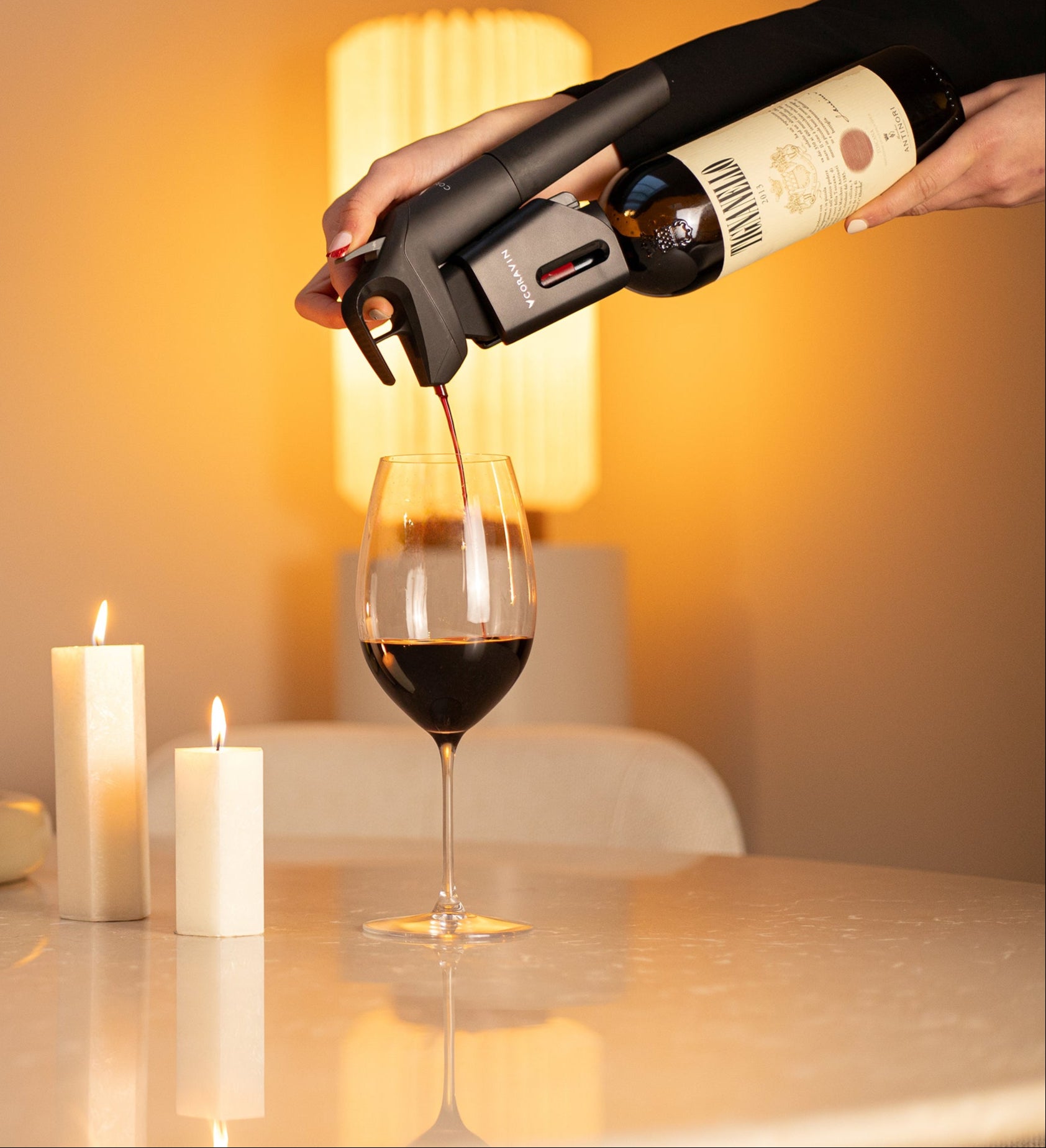 Pouring red wine using Coravin Timeless Six+™ wine by-the-glass system at home without removing the cork—perfect for wine lovers who savor wine anytime.